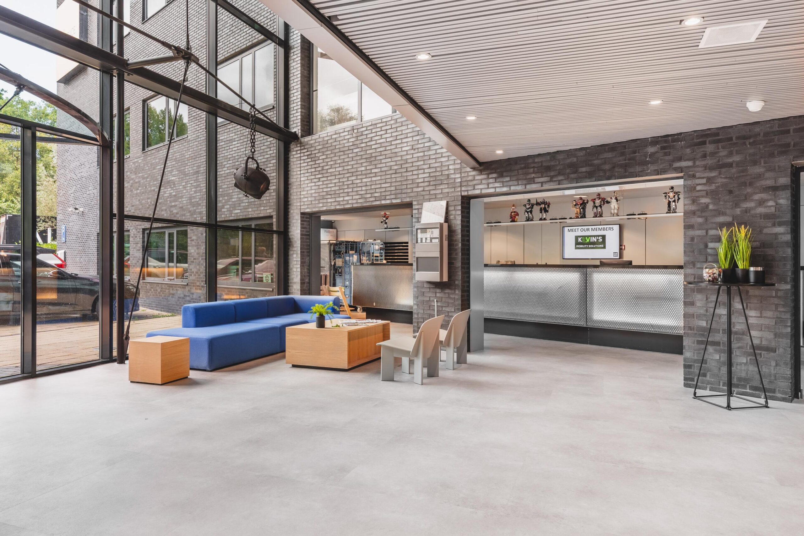 Moderne, lichte lobby aan de Prof. W.H. Keesomlaan met blauwe zithoek, balie en grote ramen.